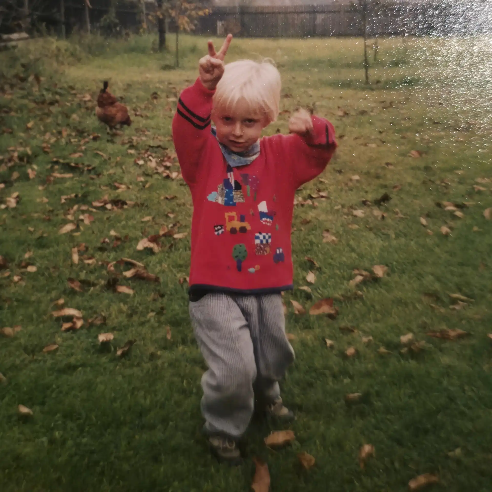 Ich auf einer Wiese im Garten meiner Großeltern mit Huhn